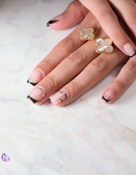 Uñas cuadradas con punta negra y charms dorados