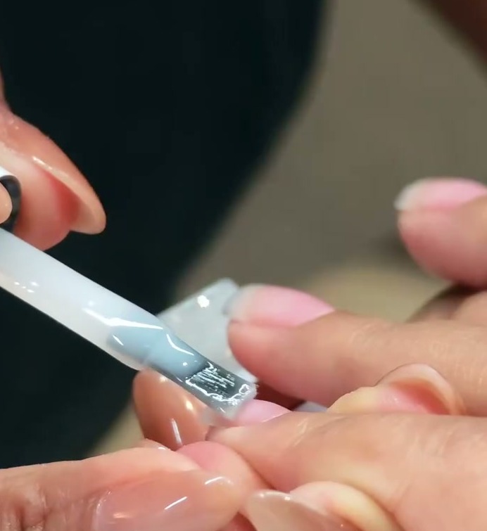 Aplicación de gel con pincel sobre la uña