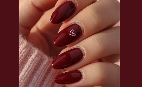 Uñas en rojo vino con detalle de corazón